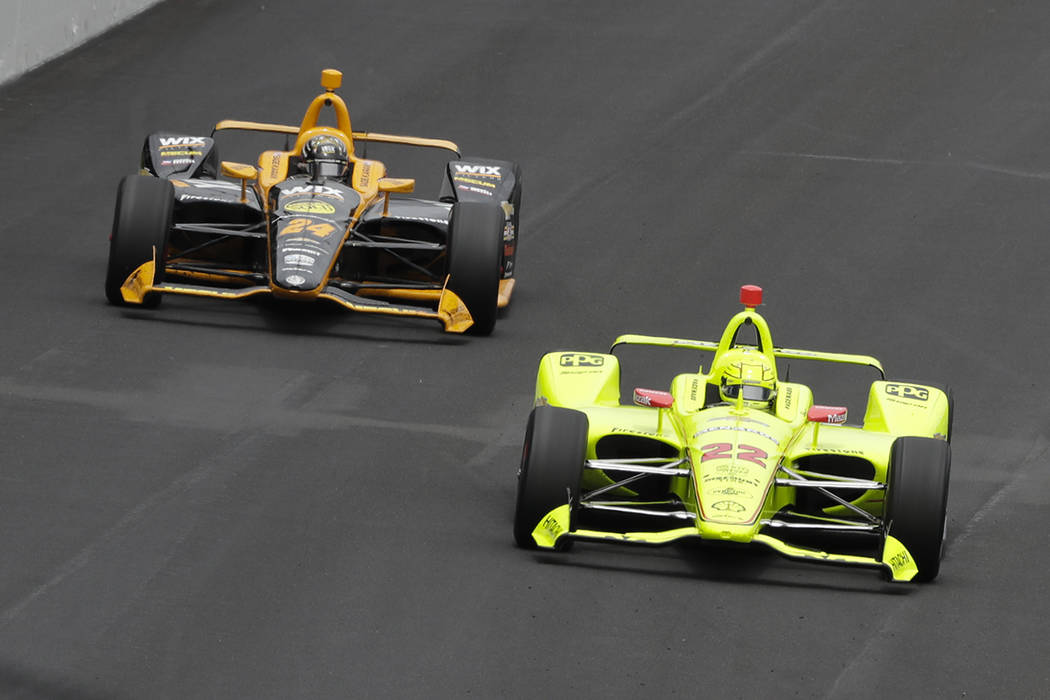 Simon Pagenaud, of France, leads Sage Karam into the first turn during the Indianapolis 500 Ind ...