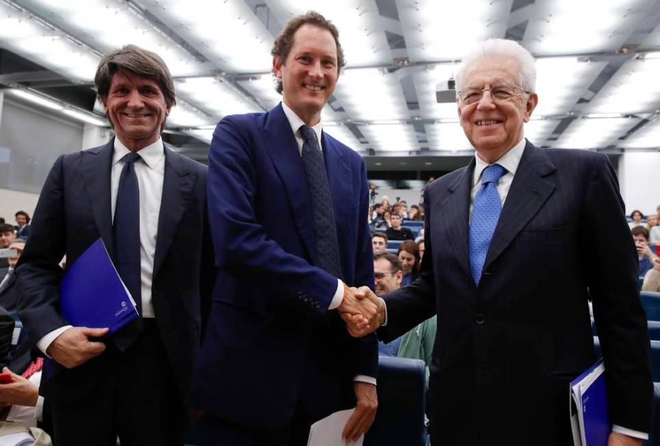 FCA Chairman John Elkann, center, shakes hands with former Italian Premier Mario Monti, right, ...