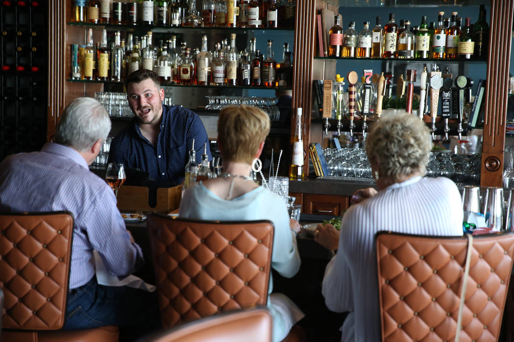 Bartender Liam Grosshauser speaks to customers at the Kitchen at Atomic in Las Vegas, Friday, M ...