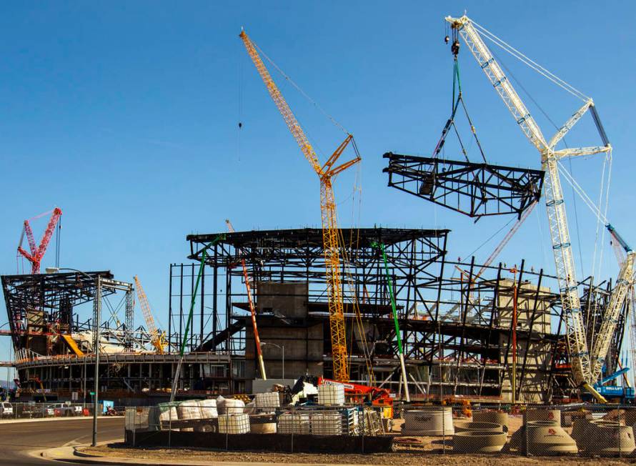 The newest truss is slowly lowered and attached into place at the top of Raiders Las Vegas Stad ...