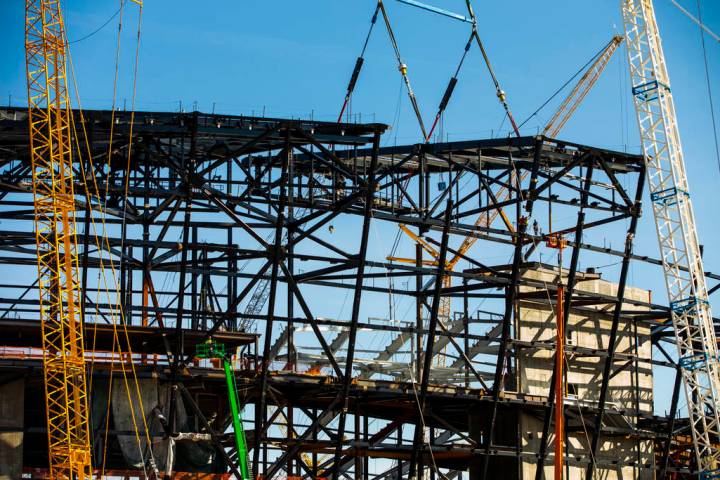 The newest truss is lowered into place and attached by awaiting steelworkers at the top of Raid ...