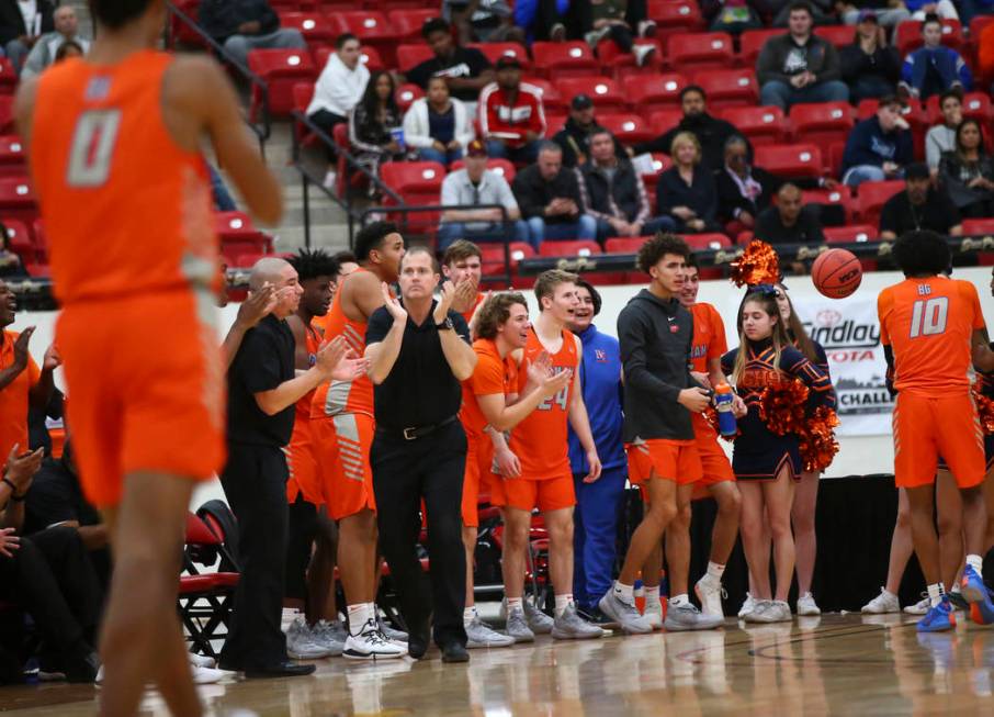 Bishop Gorman head coach Grant Rice, center left in black, celebrates as his team leads against ...