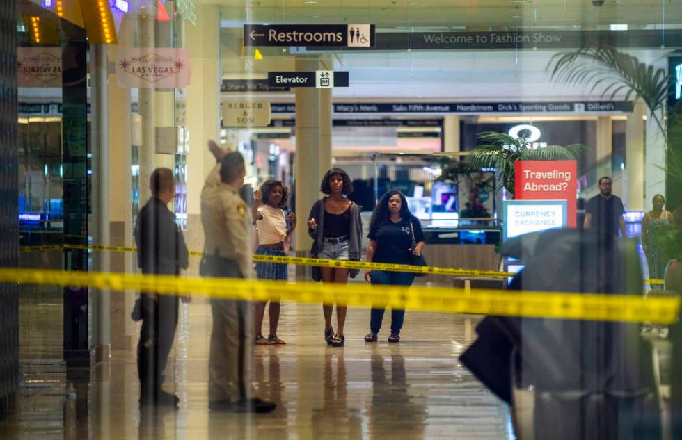 An LVMPD crime scene investigator and officer direct individuals inside the Fashion Show mall o ...