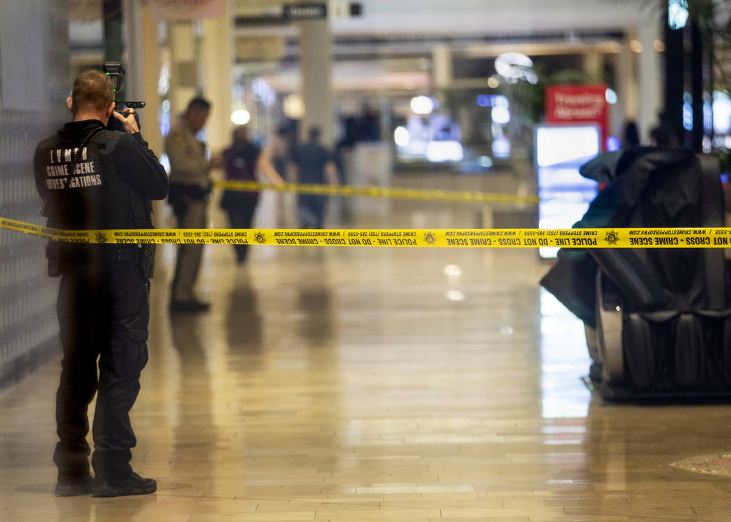 An Las Vegas police crime scene investigator shoots photographs inside the Fashion Show mall on ...
