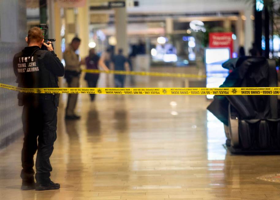An Las Vegas police crime scene investigator shoots photographs inside the Fashion Show mall on ...