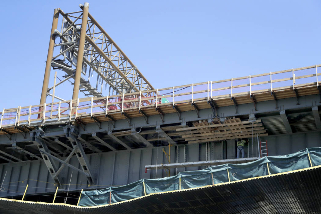 FILE - In this April 23, 2019, file photo a worker labors on the beam of the Route 495 viaduct ...