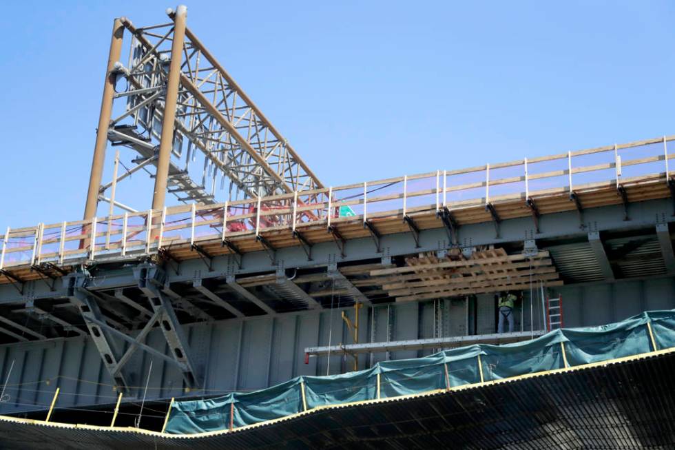 FILE - In this April 23, 2019, file photo a worker labors on the beam of the Route 495 viaduct ...