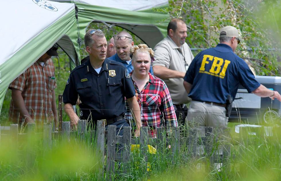 Law enforcement investigate the scene where a body that they believe to be Elizabeth Shelley wa ...