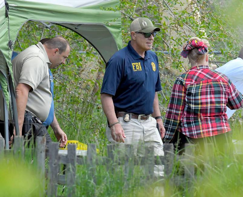 Law enforcement investigate the scene where a body that they believe to be Elizabeth Shelley wa ...