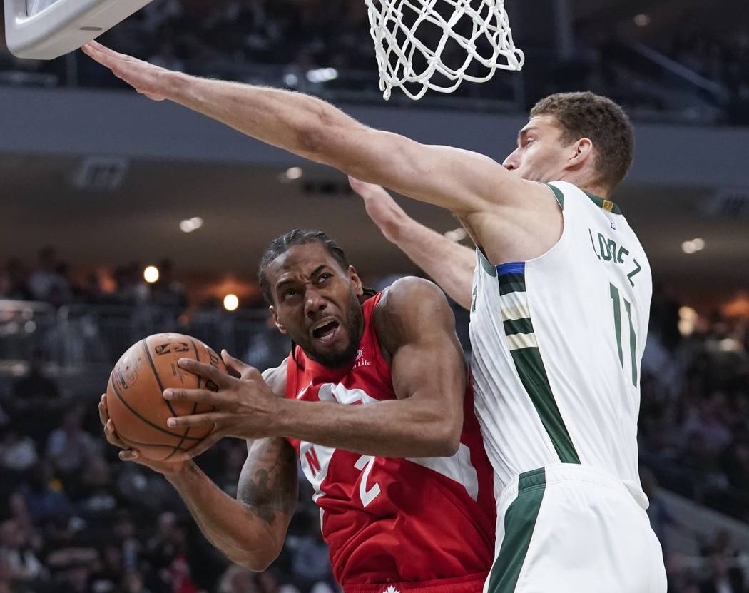 Toronto Raptors' Kawhi Leonard shoots past Milwaukee Bucks' Brook Lopez during the second half ...