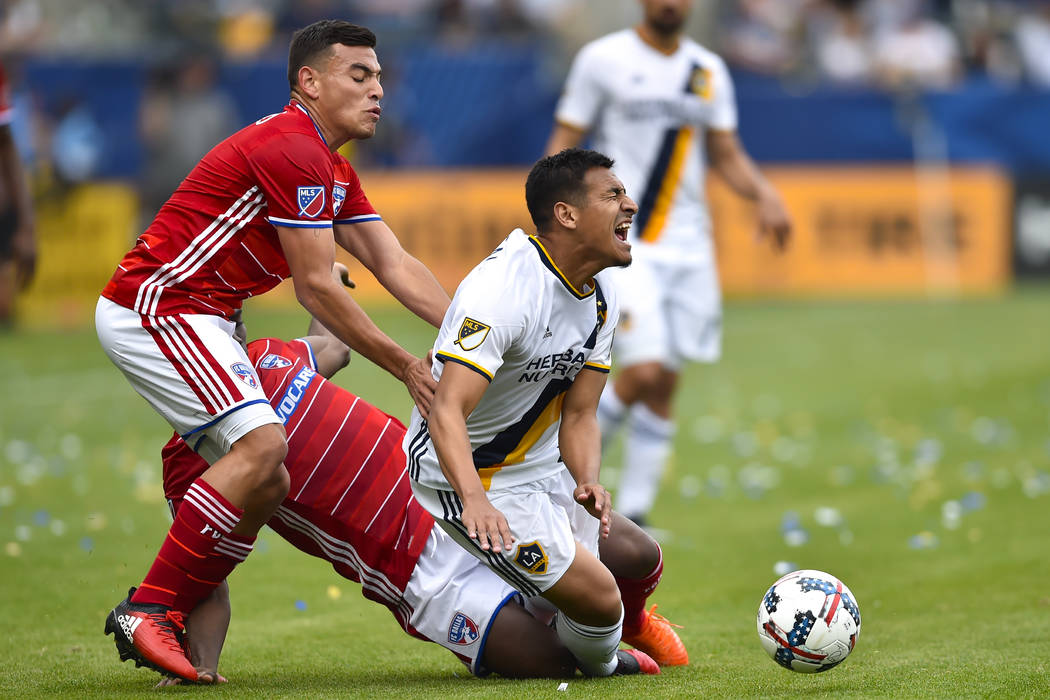 Los Angeles Galaxy midfielder Jose Villarreal, right, reacts as he gets tripped up by FC Dallas ...