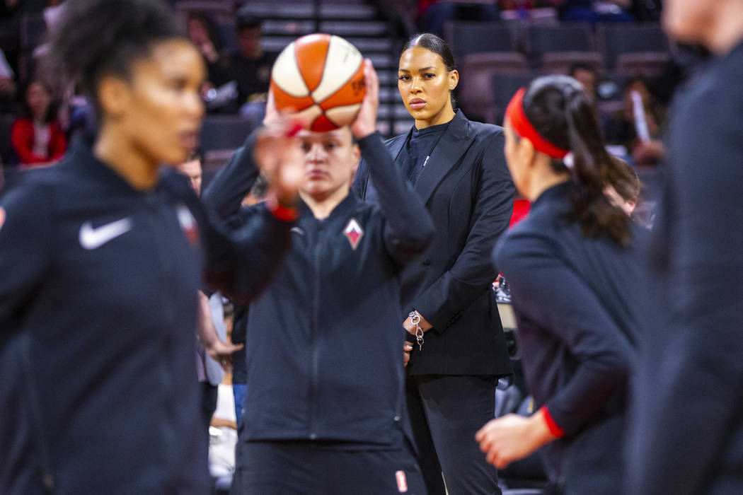 Las Vegas Aces center Liz Cambage (wearing street clothes) watches her teammates warm up before ...