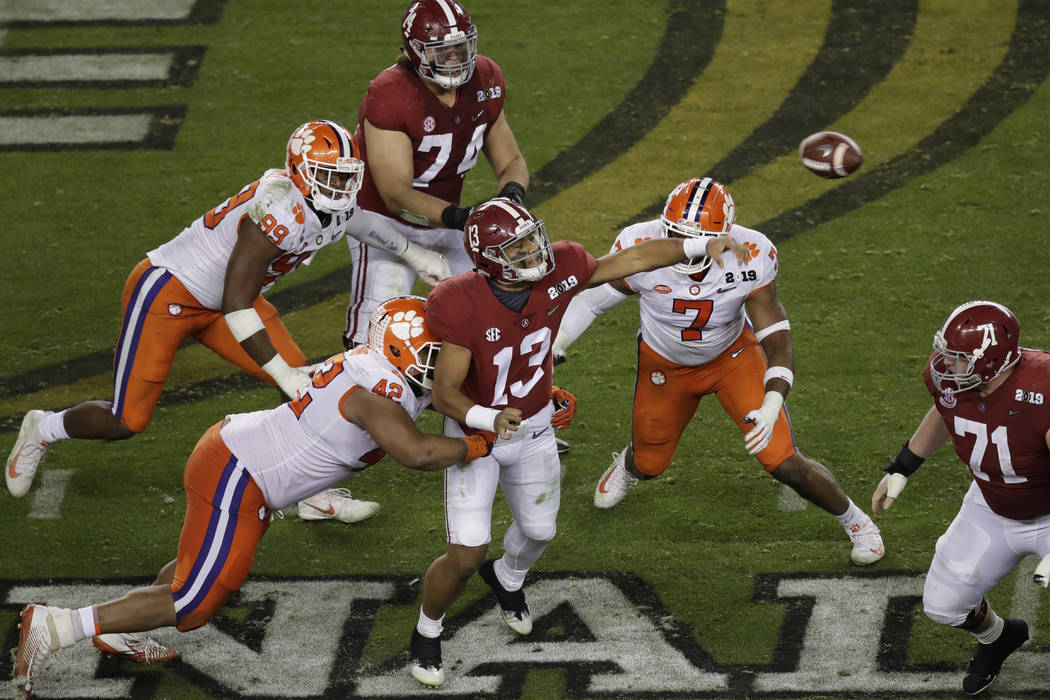 Alabama's Tua Tagovailoan throws under pressure during the second half of the NCAA college foot ...