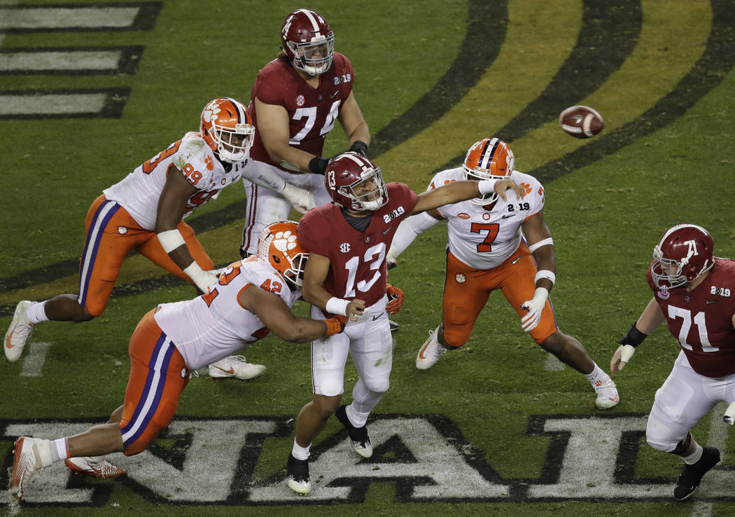 Alabama's Tua Tagovailoan throws under pressure during the second half of the NCAA college foot ...