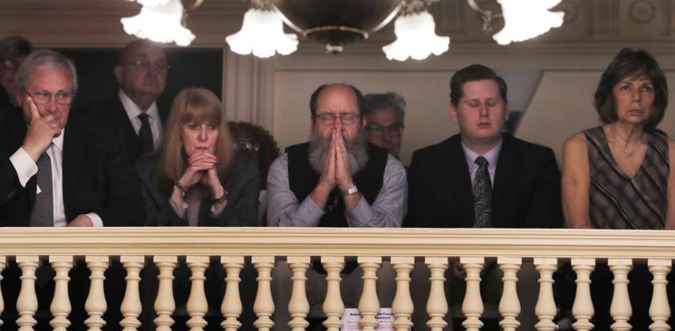 Rob Spencer, center, of Concord, N.H. pauses in prayer as legislators debate prior to a death p ...