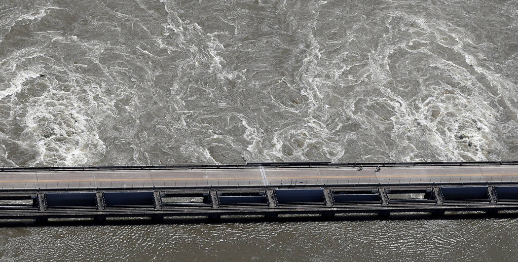 In this Wednesday, May 29, 2019 photo, two cyclists ride along the Old River Control Structure, ...