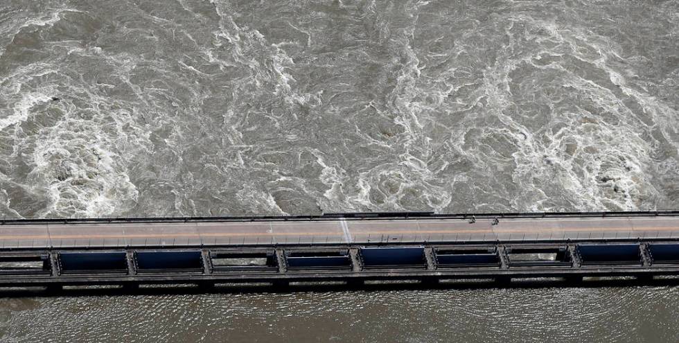 In this Wednesday, May 29, 2019 photo, two cyclists ride along the Old River Control Structure, ...