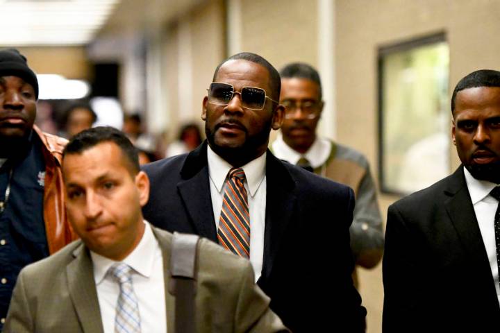 Musician R. Kelly, center, leaves the Daley Center after a hearing in his child support case, M ...