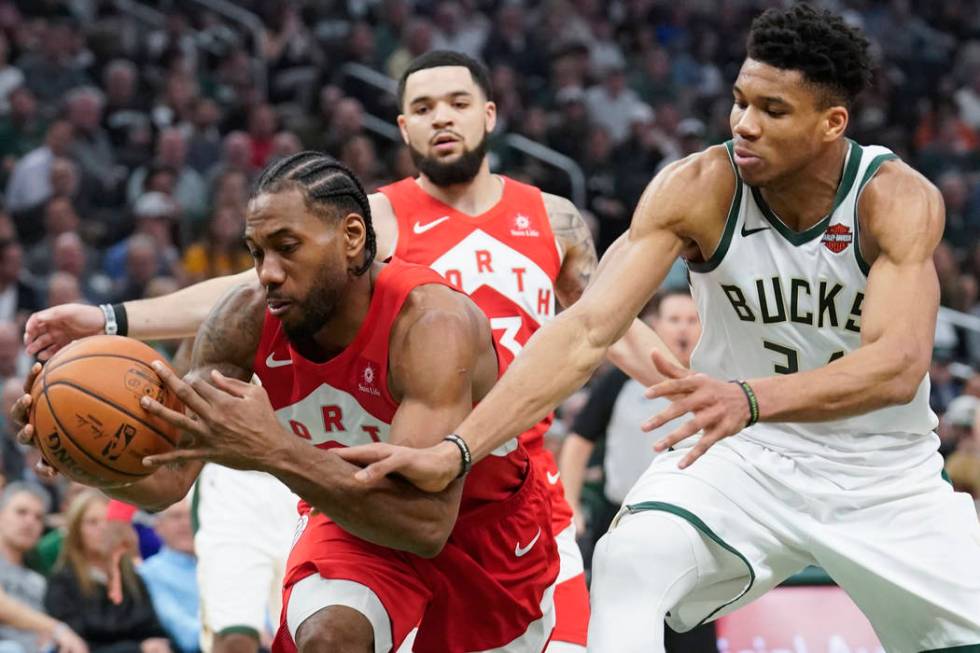 Milwaukee Bucks' Giannis Antetokounmpo and Toronto Raptors' Kawhi Leonard go after a loose ball ...