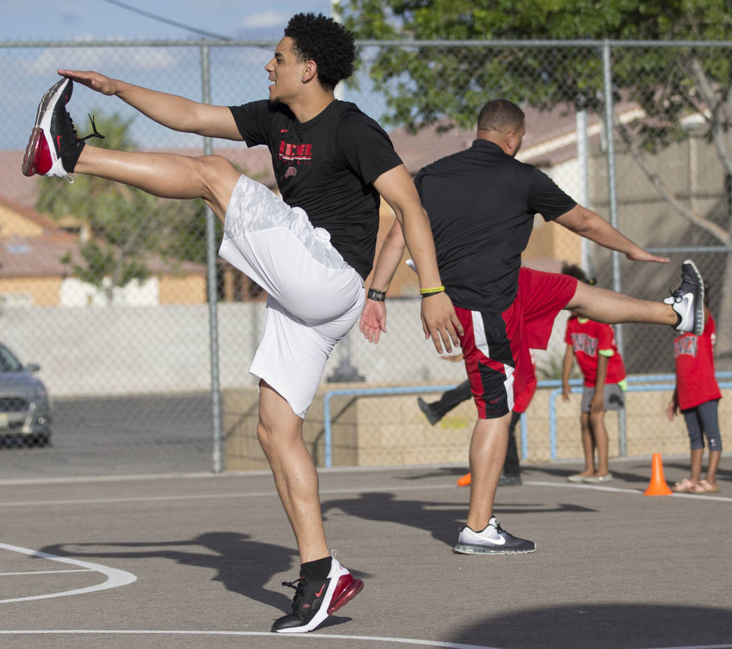 UNLV player Marvin Coleman II, left, demonstrates a stretch during a youth clinic hosted by UNL ...