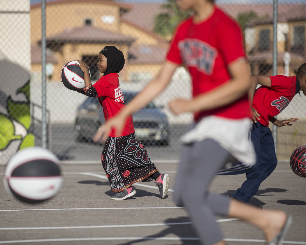 Fardosa Blial, left, 6, dribbles a basketball during a youth clinic hosted by UNLV head basketb ...