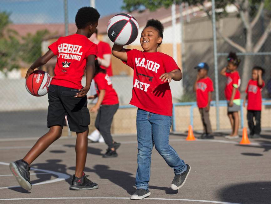 Kids with the Nevada Youth Network practice dribbling during a youth clinic hosted by UNLV head ...