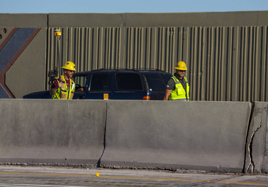 A work crew walks along as traffic lanes are reduced on U.S. Highway 95 near Rancho Drive with ...