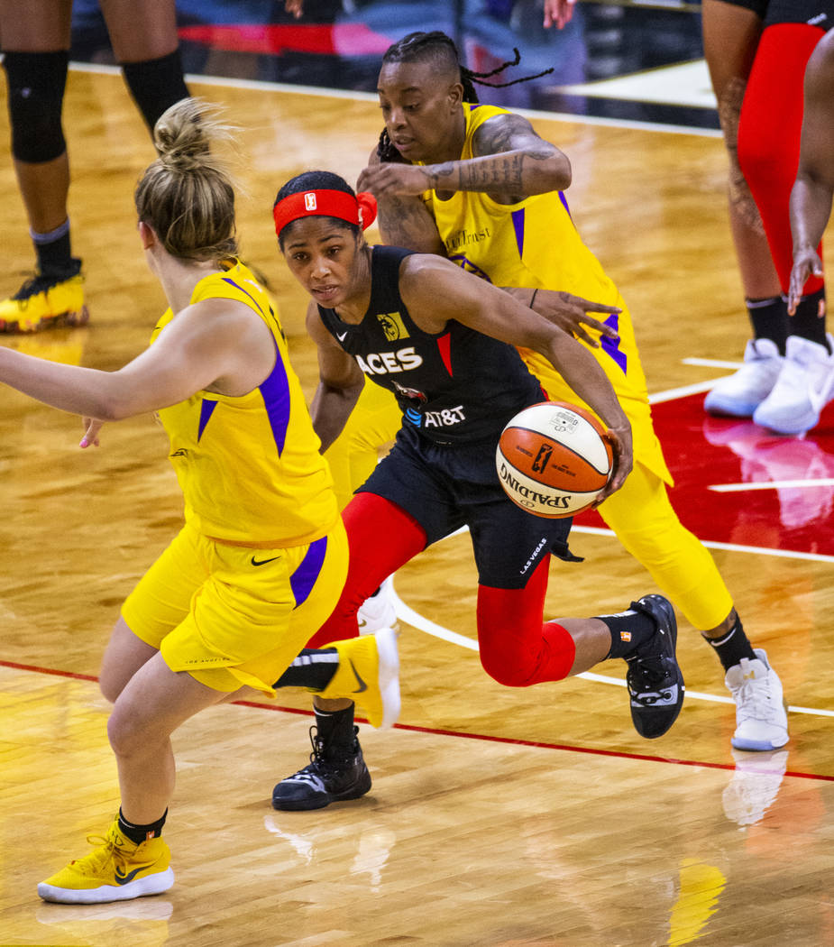 Las Vegas Aces guard Sydney Colson (51) drives the court between Los Angeles Sparks guard Marin ...