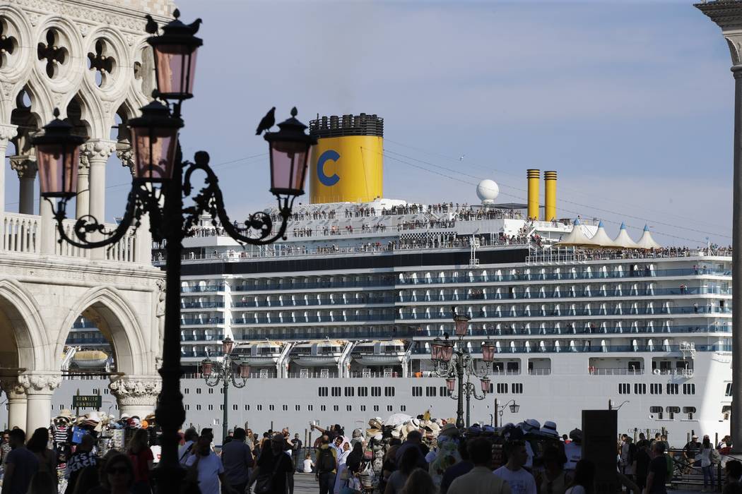 A cruise ship passes by St. Mark's Square filled with tourists, in Venice, Italy, Sunday, June ...