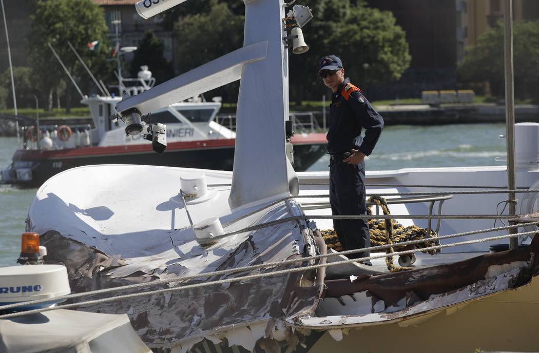 An Italian Coast Guard officer stands on the tourist boat that was struck by a cruise line ship ...