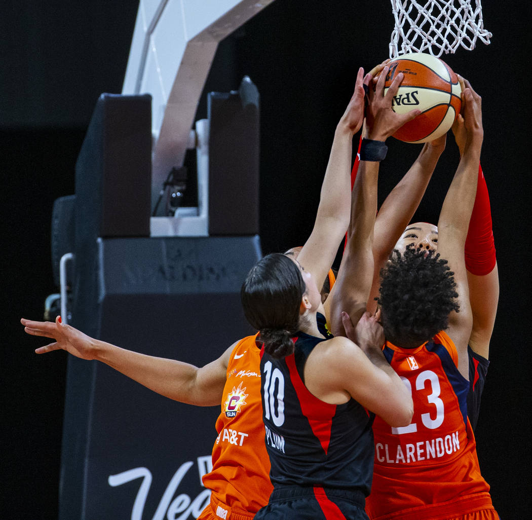 Las Vegas Aces guard Kelsey Plum (10) and teammate center Ji-Su Park (19) team up to take a reb ...