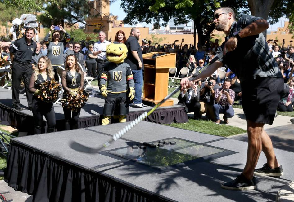 Vegas Golden Knights defenseman Deryk Engelland hits a puck through a ceremonial plate of glass ...