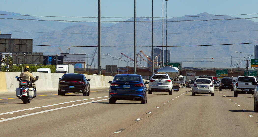 A Las Vegas Metropolitan motorcycle officer trails a vehicle in the HOV lane northbound on Inte ...