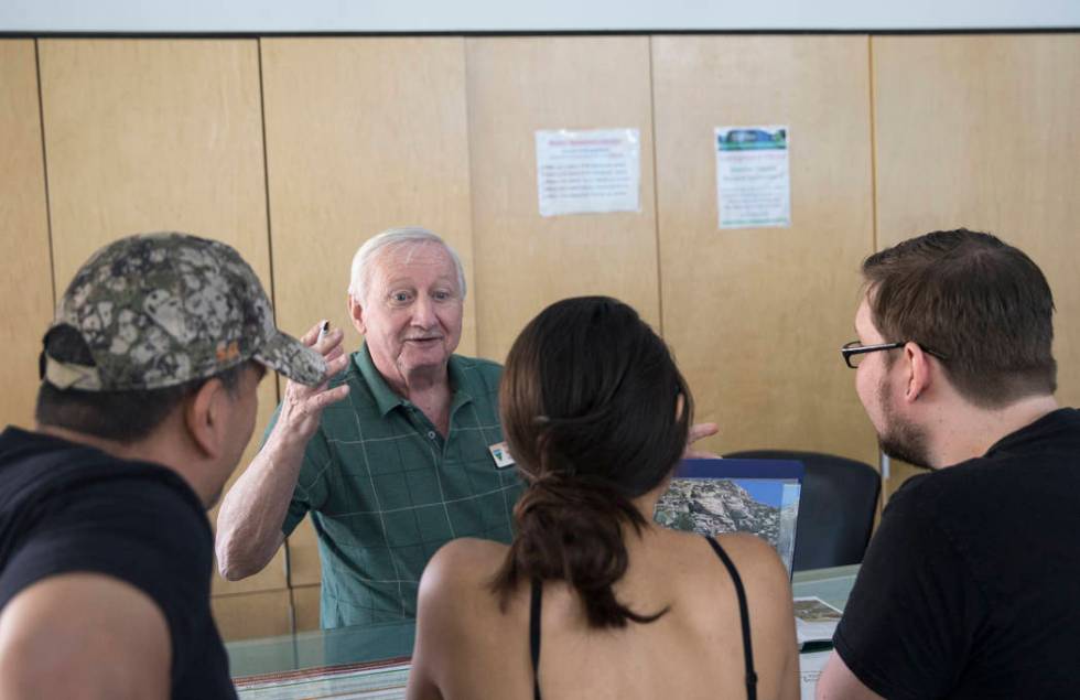 Roy Mills, center left, a volunteer with the Bureau of Land Management, talks with visitors dur ...