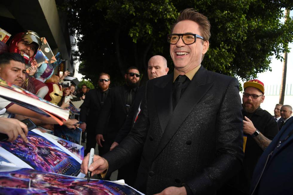 In an April 22, 2019, file photo Robert Downey Jr. signs autographs as he arrives at the premie ...