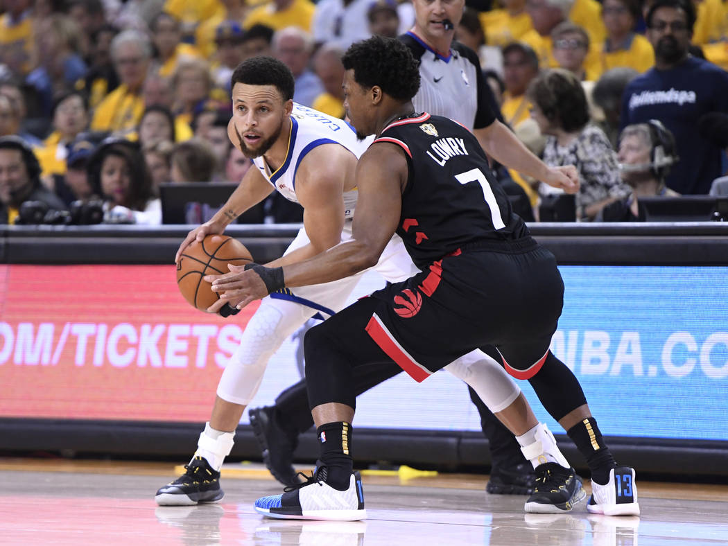 Toronto Raptors guard Kyle Lowry (7) defends against Golden State Warriors guard Stephen Curry ...