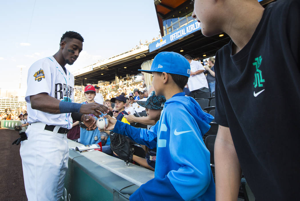 Las Vegas Aviators shortstop Jorge Mateo signs items for a group of young fans before the start ...