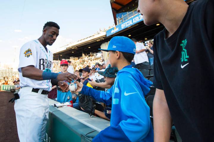 Las Vegas Aviators shortstop Jorge Mateo signs items for a group of young fans before the start ...