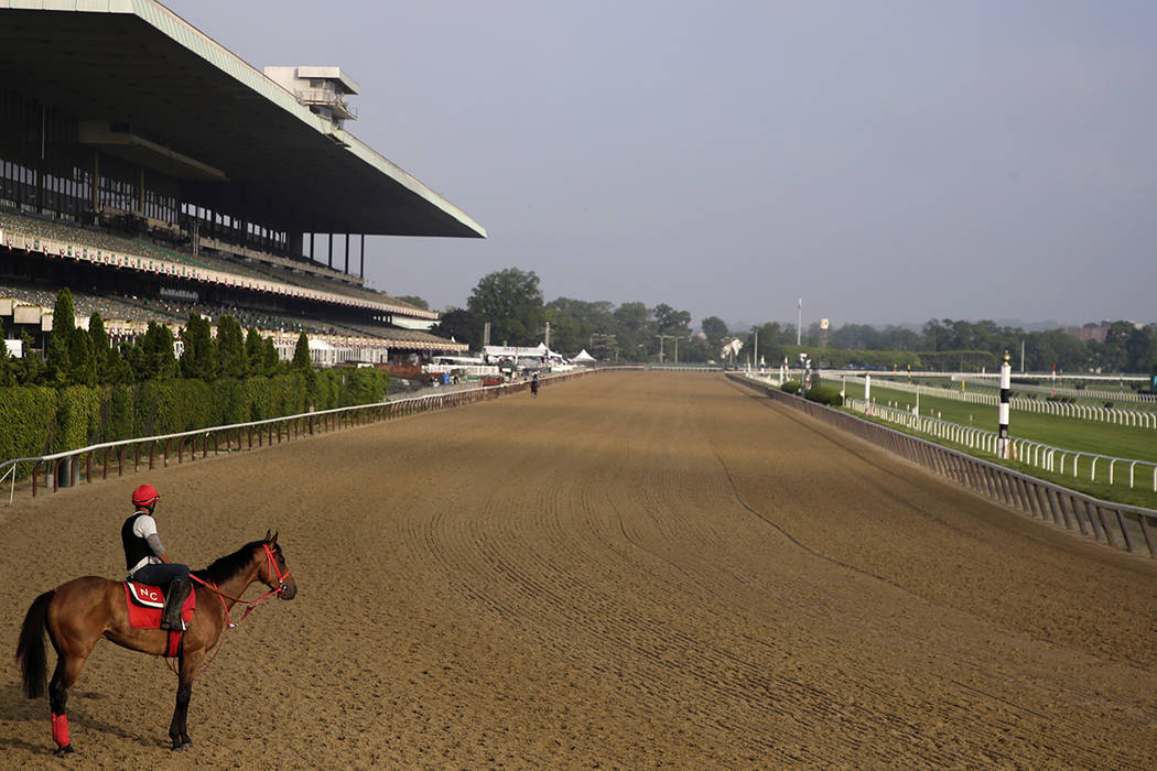 A rider looks out over a mostly empty track during workouts at Belmont Park in Elmont, N.Y., Th ...