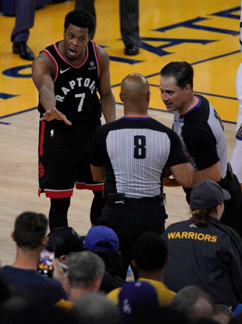 Toronto Raptors guard Kyle Lowry (7) gestures next to referees Marc Davis (8) and referee Kane ...