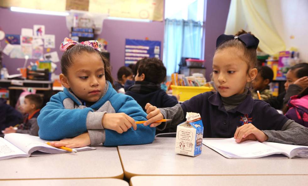 E'liana Trujillo borrows a pencil from Maryah Villezcas in Shamika Abbott's first-grade class a ...