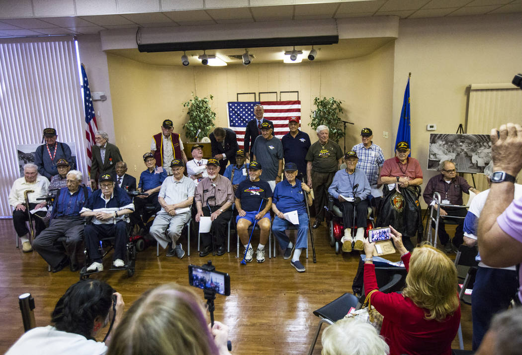 World War II veterans pose for a photo after a ceremony commemorating the 75th anniversary of t ...