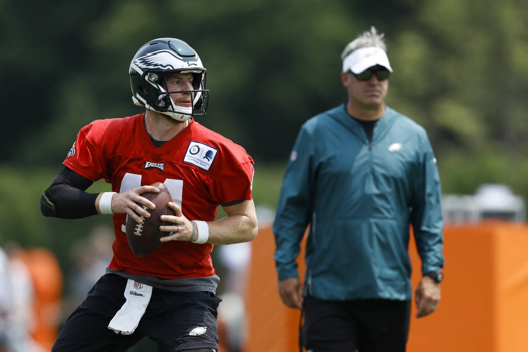 Philadelphia Eagles' Carson Wentz, left, participates in a drill as head coach Doug Pederson lo ...