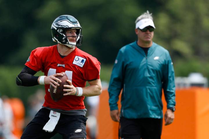 Philadelphia Eagles' Carson Wentz, left, participates in a drill as head coach Doug Pederson lo ...