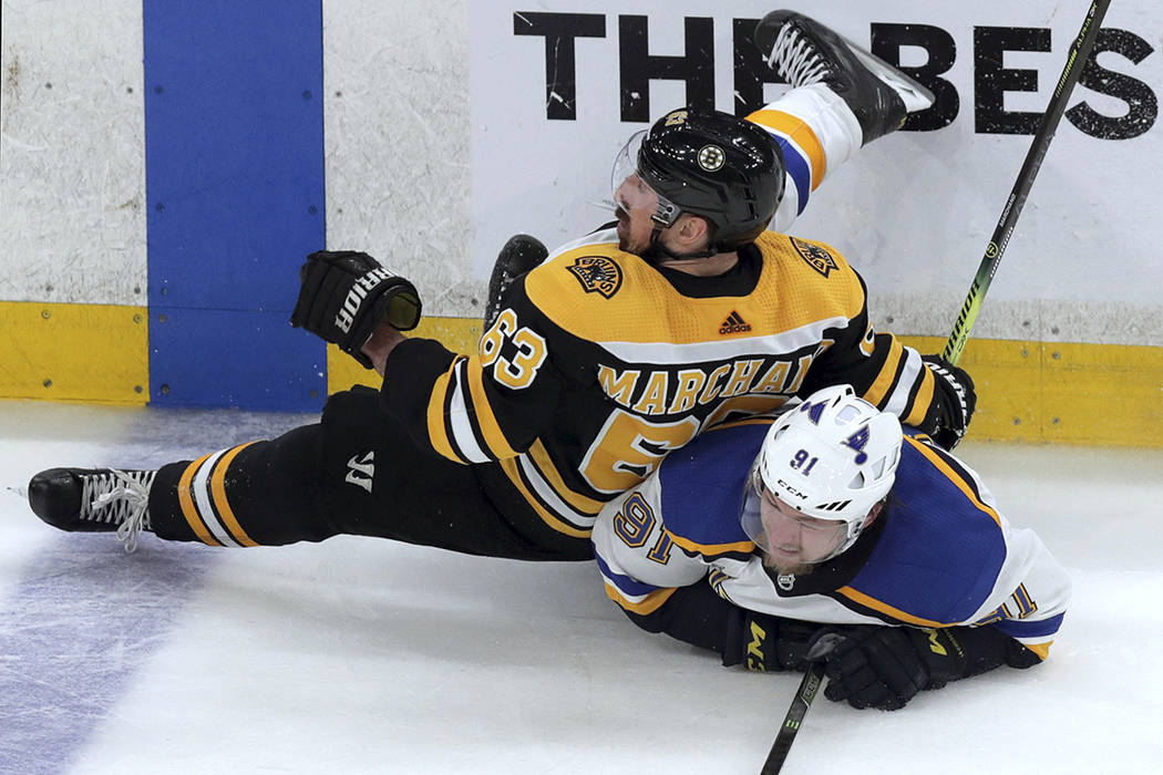 Boston Bruins' Brad Marchand, left, checks St. Louis Blues' Vladimir Tarasenko, of Russia, to t ...