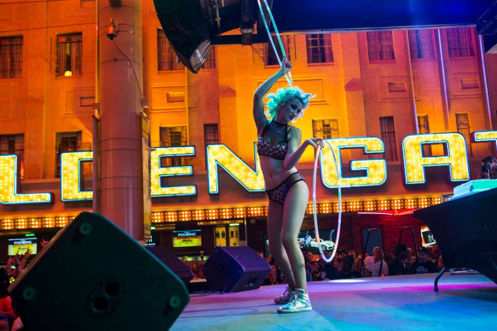 A dancer performs before an appearance by Steve Aoki at the Fremont Street Experience in downto ...