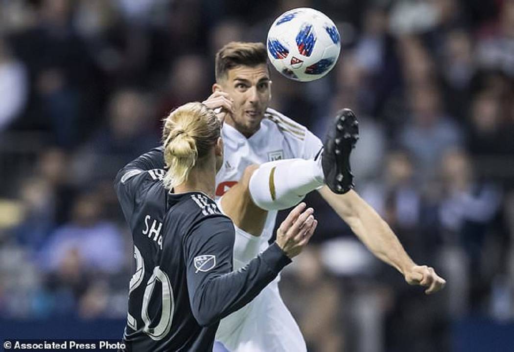 Los Angeles FC's Dejan Jakovic, back, leaps to kick the ball away from Vancouver Whitecaps' Bre ...