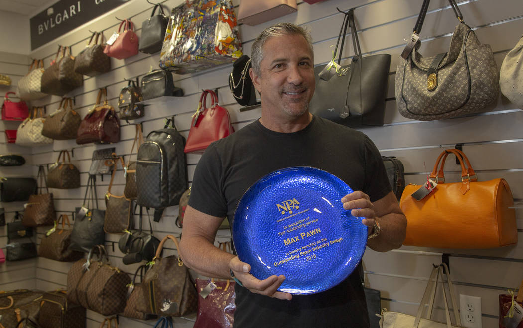 Michael Mack stands in front of luxury purses at Max Pawn in Las Vegas, Thursday, June 6, 2019. ...