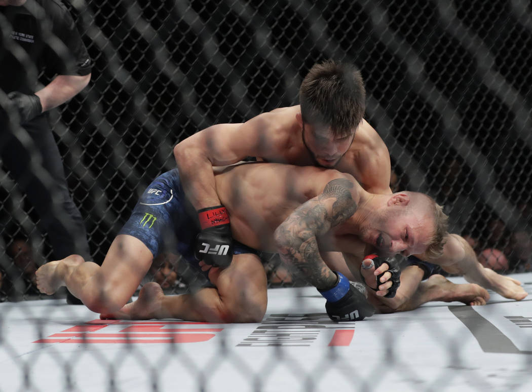 Henry Cejudo, above, wrestles with TJ Dillashaw during the first round of a flyweight mixed mar ...
