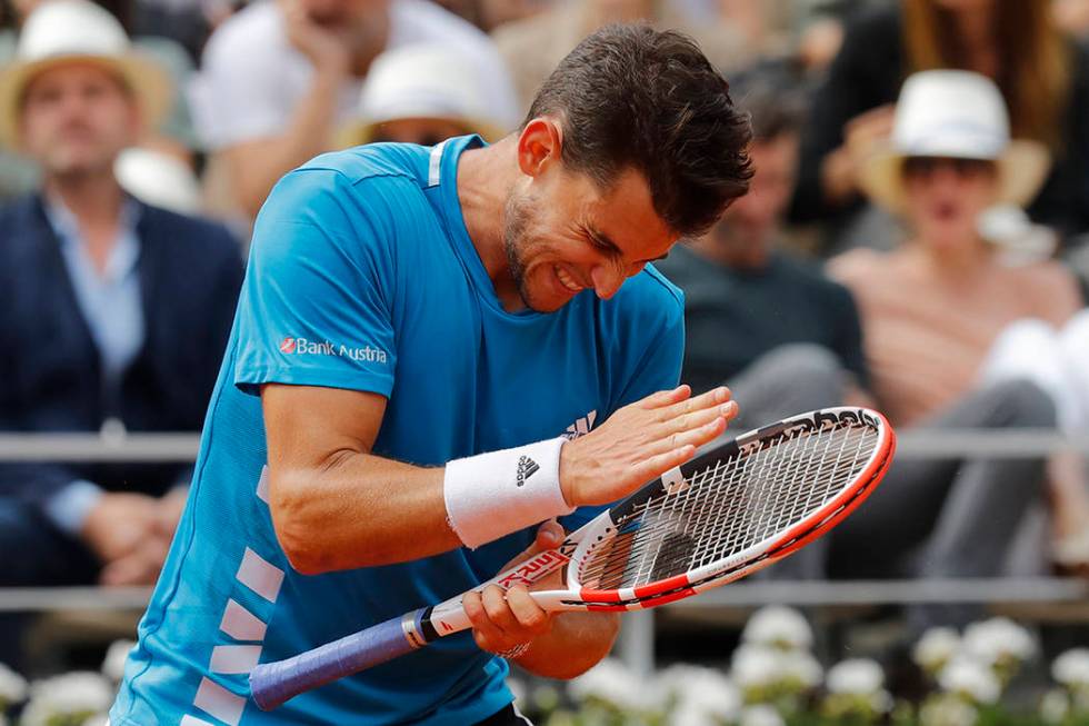 Austria's Dominic Thiem hits his racket after hitting a shot into the net in the second set aga ...